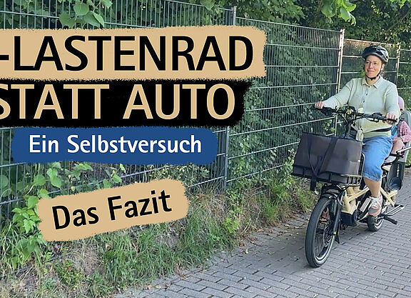 Frau transportiert Kind auf dem E-Lastenrad